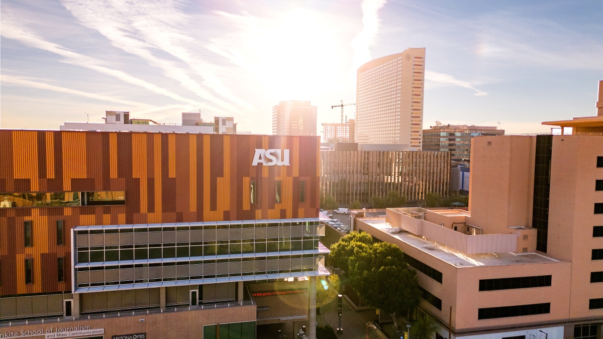 The sun casts rays over the top of an orange and maroon striped building with an ASU®168极速入口一分钟赛车网 sign